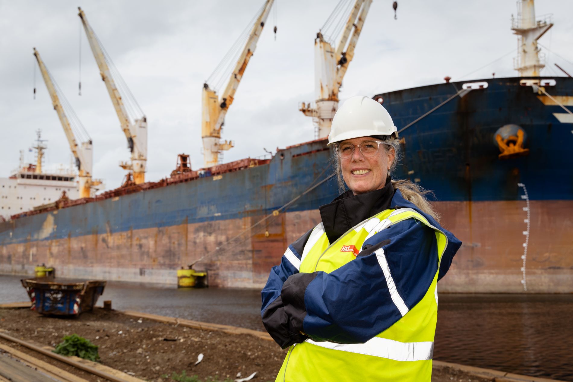 Schip in haven met op voorgrond een inspecteur van de omgevingsdienst